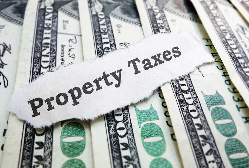 Property Taxes paper message on assorted money