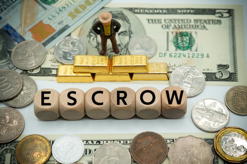 Escrow is a legal concept describing a financial instrument.Money, securities, funds, and other assets.The word is written on money and gold background