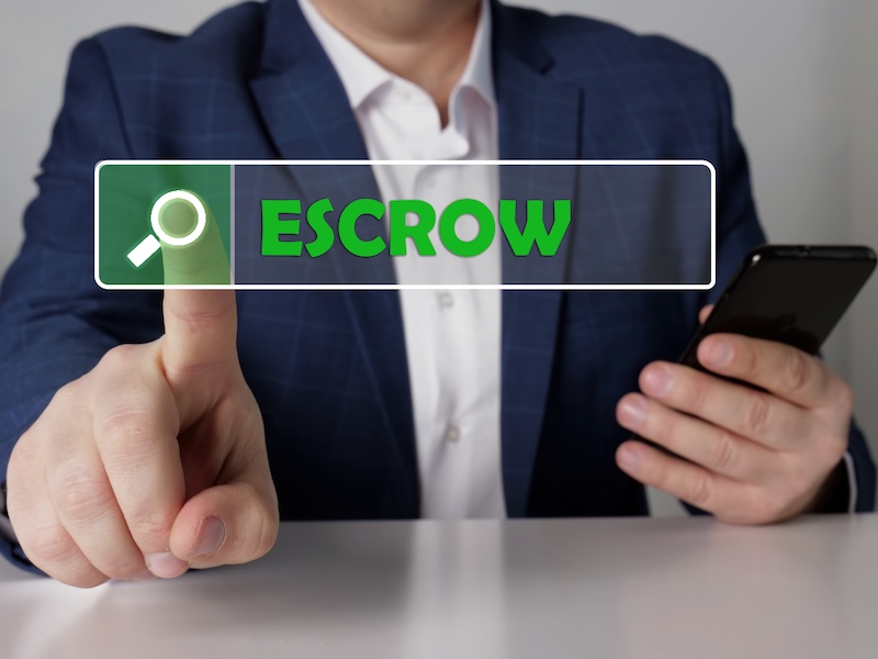 ESCROW text in search line. Loan officer looking for something at smartphone. ESCROW concept.