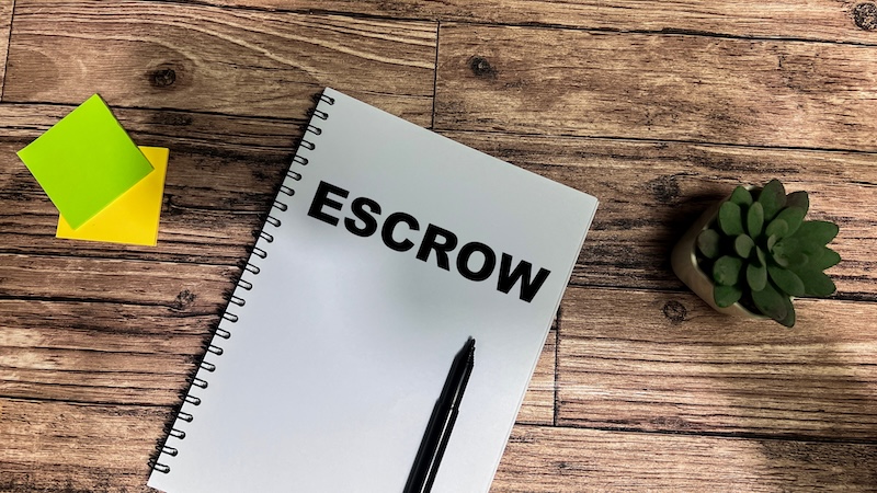 Concept of Escrow write on book isolated on Wooden Table.