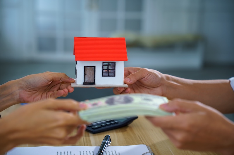 A real estate house model cash payment contract exchange office buyer seller show home purchase, mortgage loan approval, property sale closing on table with document, pen, calculator